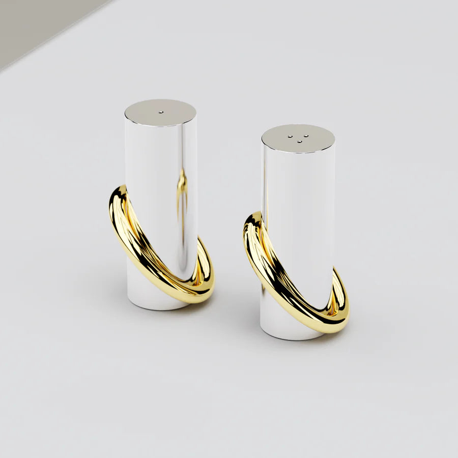 Our Ring Salt and Pepper shakers are stable only when the design elements lean against each other—a visual metaphor to encourage people to support one another. Crafted from hand-polished stainless steel and solid brass, these elegant shakers blend style with function. Designed to adorn your kitchen and dining table alike, they elevate any meal.

Stainless Steel and Brass
Imported
Clean the pieces with mild, soapy water and a soft cloth
2" x 2" x 3.5"